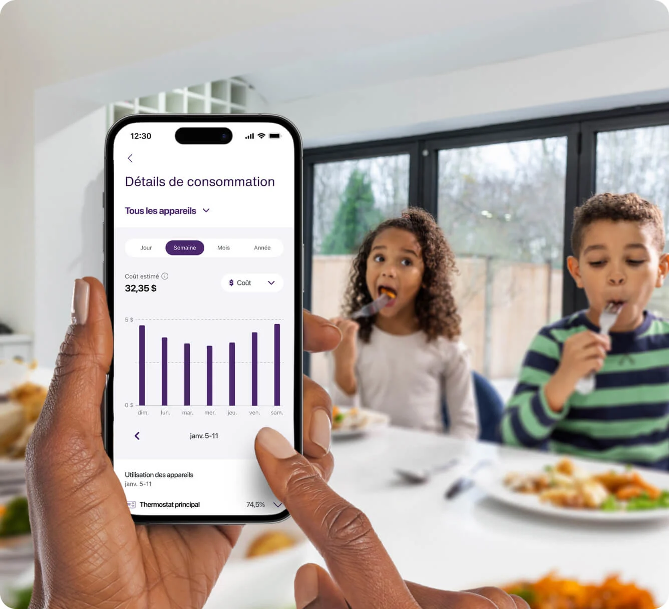 Personne tenant à la main, pendant le petit-déjeuner des enfants, un appareil où sa consommation et ses habitudes en la matière s’affichent dans l’application TELUS MC+. 