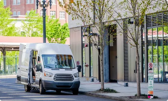 White delivery van parked on urban street.