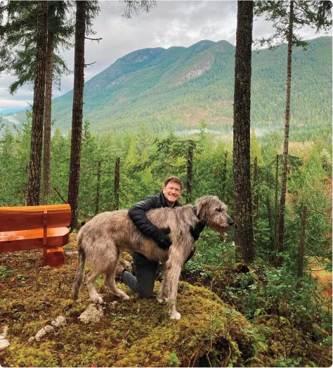 Darren Entwistle, président et chef de la direction de TELUS, en randonnée dans la forêt avec son chien.
