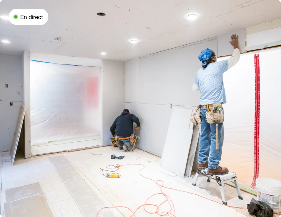 2 hommes dans une pièce faisant des travaux de construction