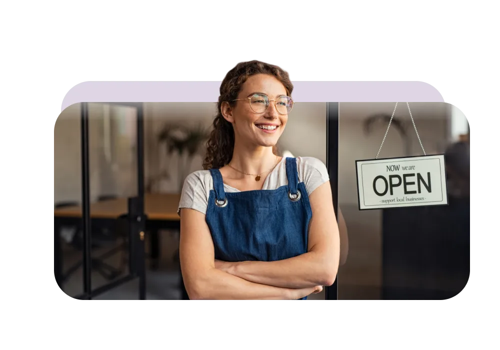 Une femme devant une boutique dont le signe indique « On est ouvert - encouragez les entreprises locales ».