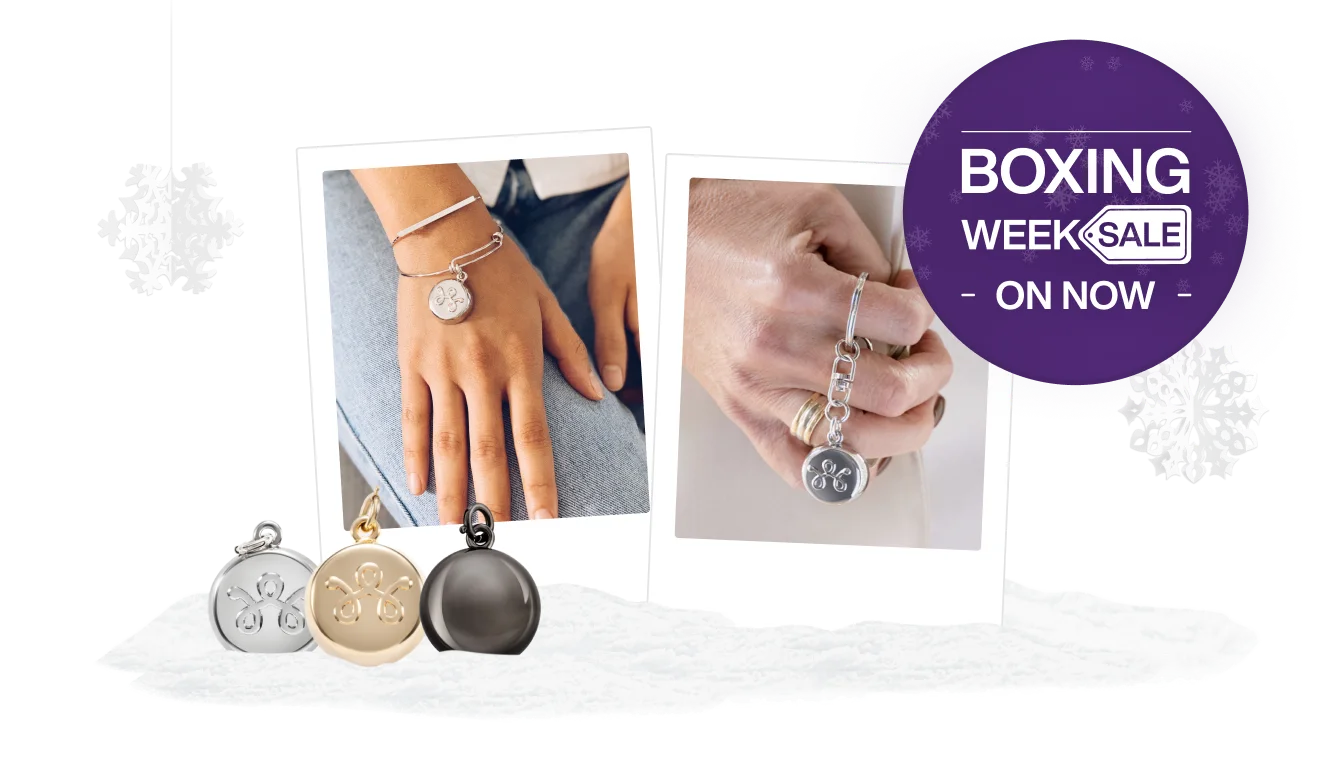 Three SmartWear Security charms next to two close ups of individuals holding a stylish device. A roundel on the right reads “Boxing Week sale on now”.