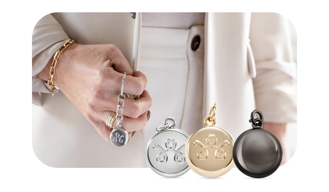 A close up of an individual’s hand holding a stylish SmartWear Security device