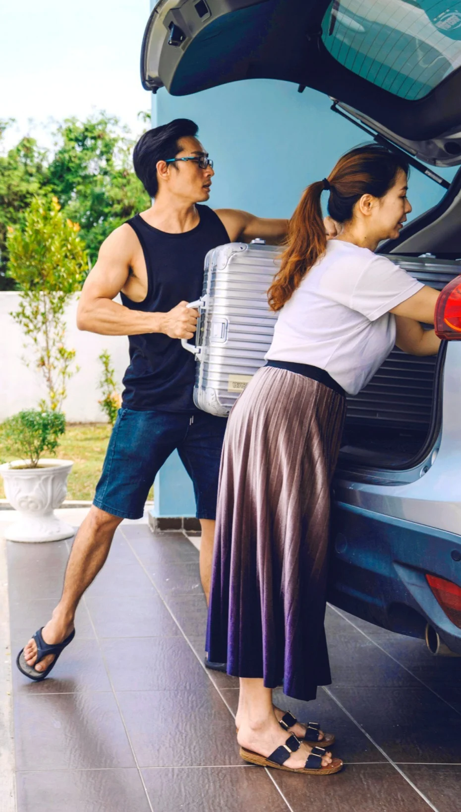 Un couple charge la voiture pour un voyage sur la route. 