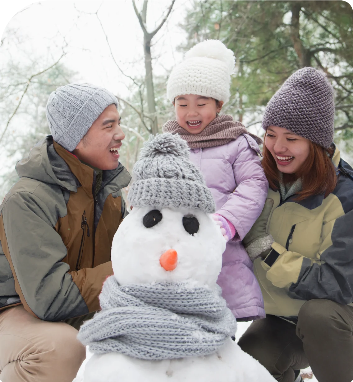 A family builds a snowman.