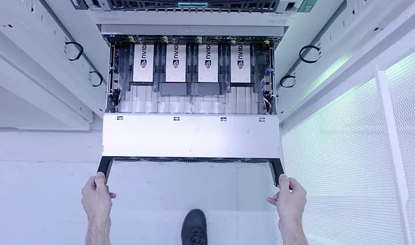 Top-down view of hands installing a server tray with NVIDIA processors into a data center rack