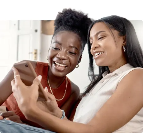 Two young females are engaged with content on a smartphone device.