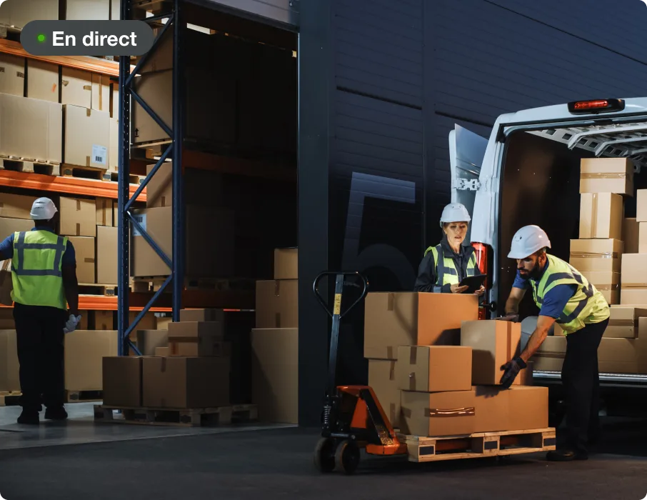 Travailleurs chargeant des boîtes dans un camion dans un entrepôt.