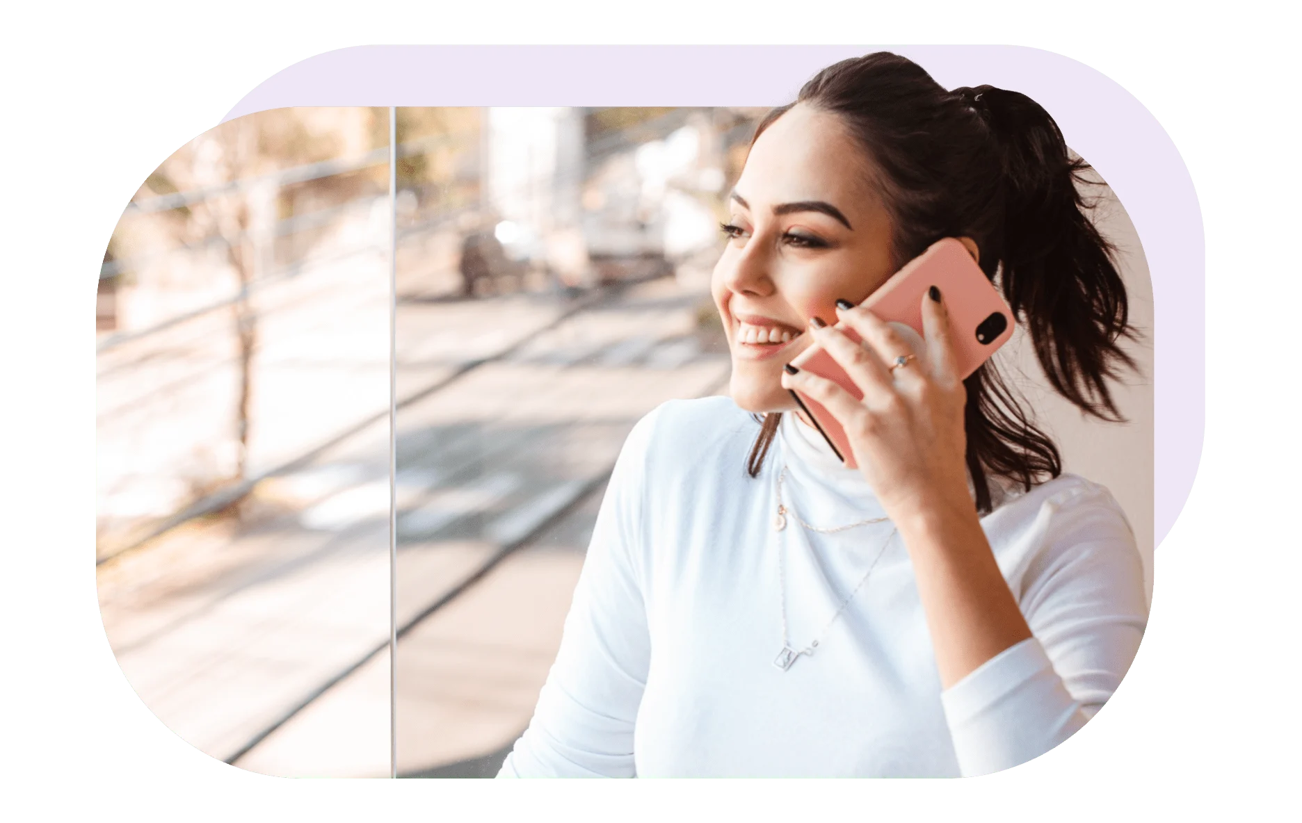 While having a conversation on the phone, a woman gazes out the window. 