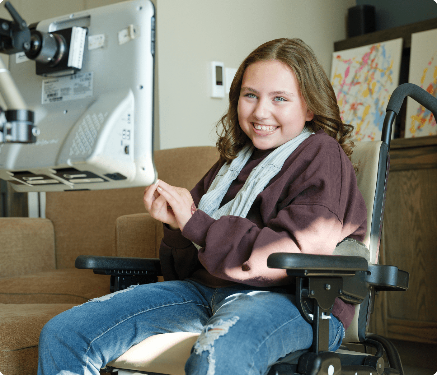 Olivia, tout sourire dans son fauteuil roulant, pendant qu’elle utilise la technologie d’interface cerveau-machine.