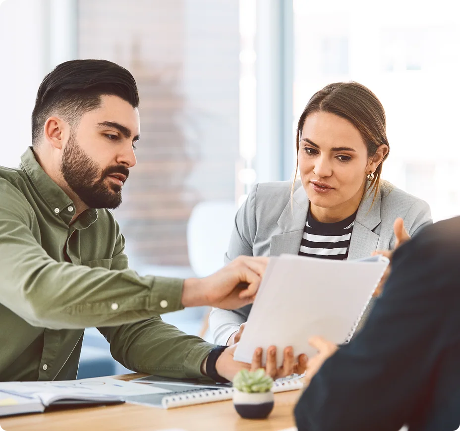 Business professionals reviewing documents in conference room meeting.