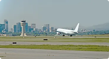 Commercial aircraft taking off from urban airport runway.