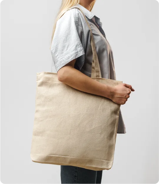 A person holding a large beige shopping bag