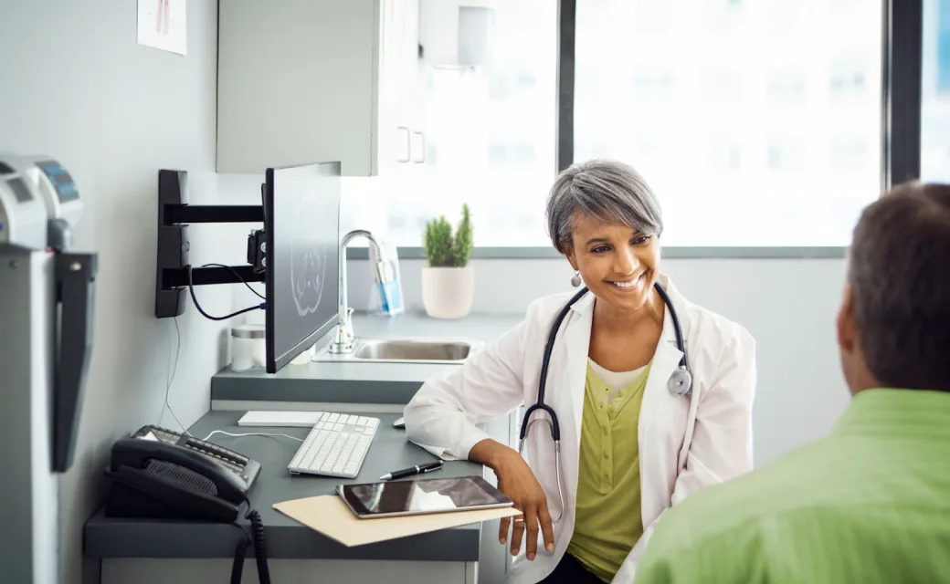 Female doctor wearing stethoscope speaking with patient in an office setting