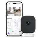 A smartphone next to a security camera.