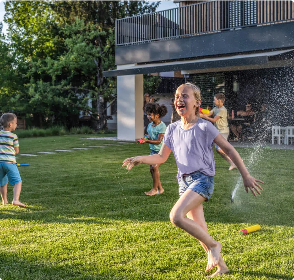 A TELUS Outdoor Camera shows a family playing in the backyard. 