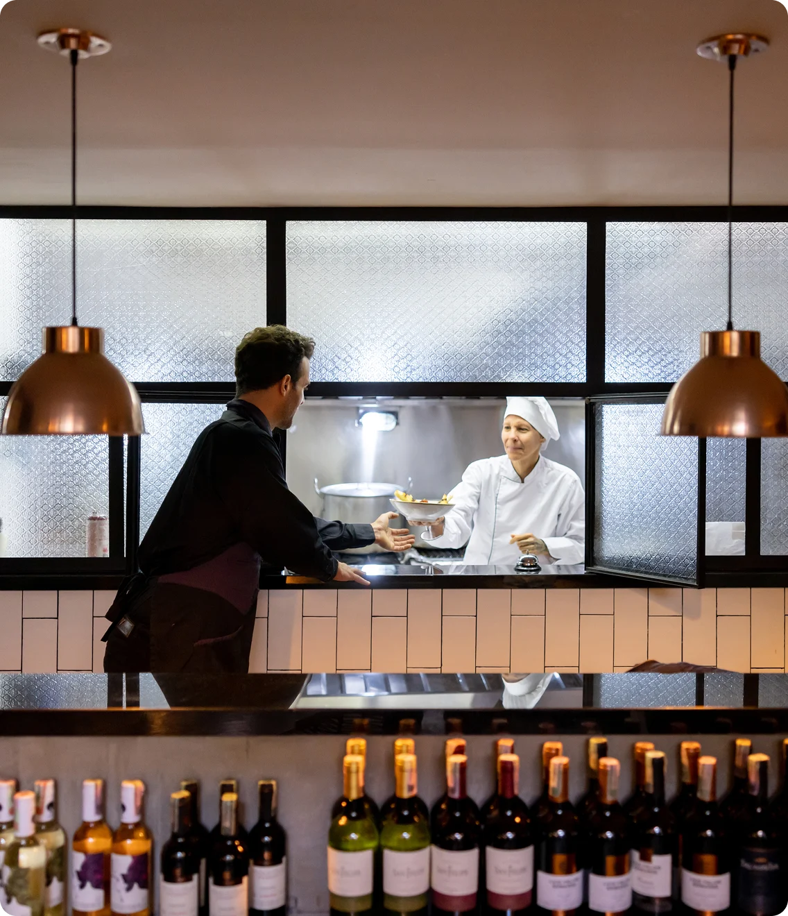 Chef serving customer in modern restaurant with integrated service setup