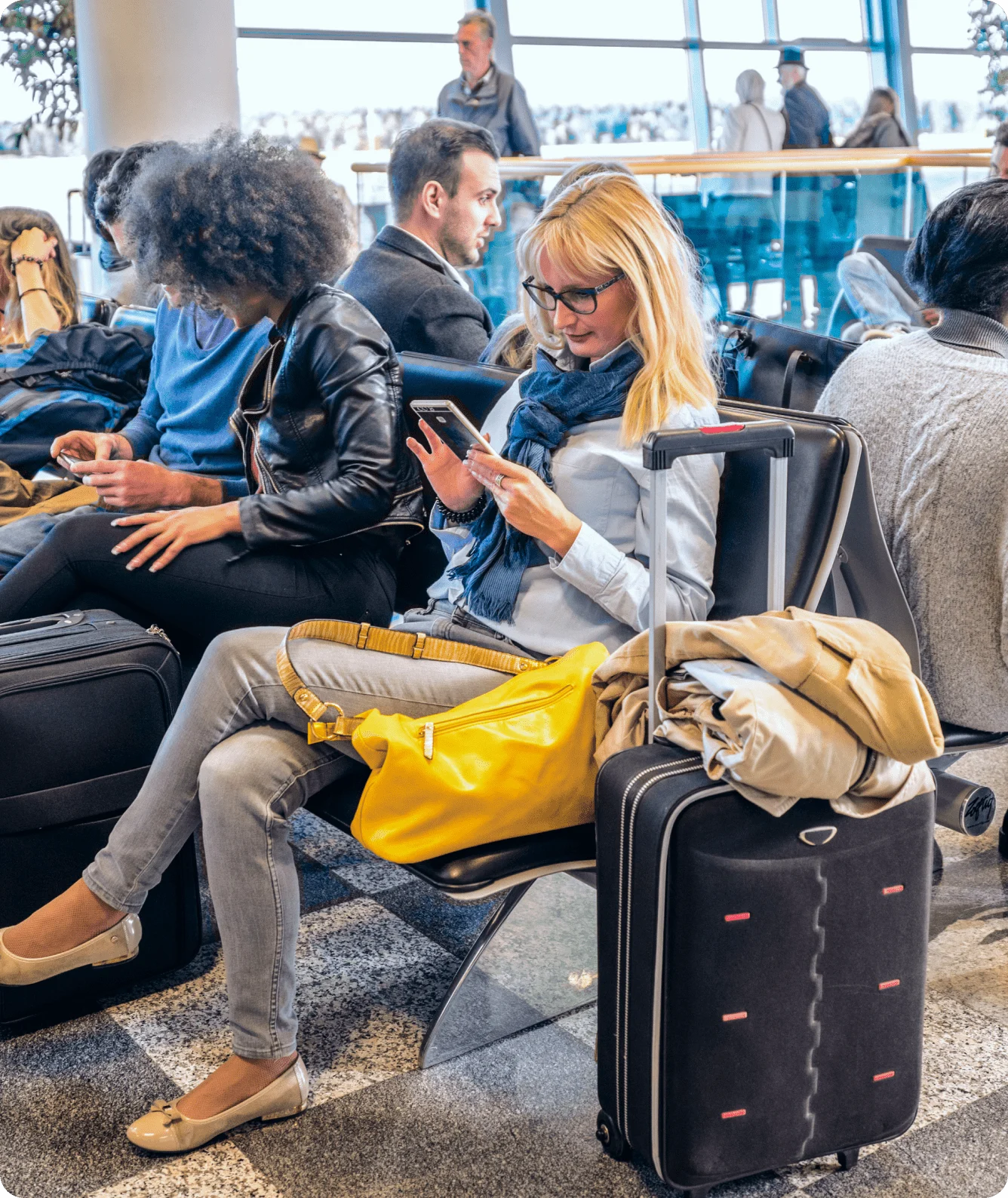 A woman using Norton Private Browser on her smartphone in a crowded airport.