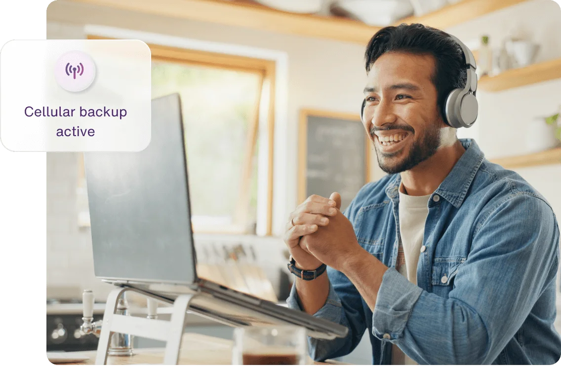 A man working from his laptop using Internet Backup during a home Wi-Fi disruption.