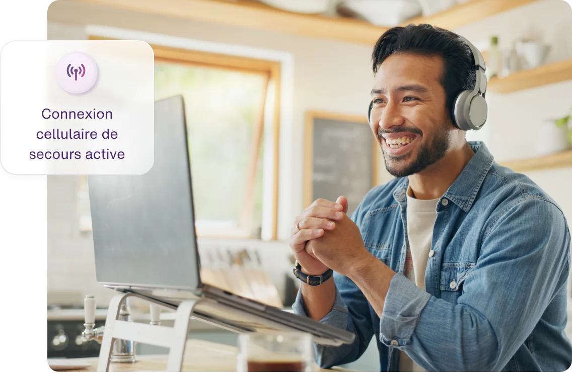 Un homme travaille sur son ordinateur en utilisant la fonction Connexion Internet de secours durant une interruption du Wi-Fi.