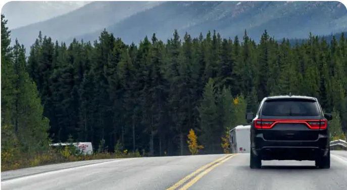 Voiture sur une route panoramique à travers une forêt d’automne