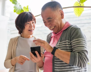 A senior couple sharing a laugh while viewing a smartphone