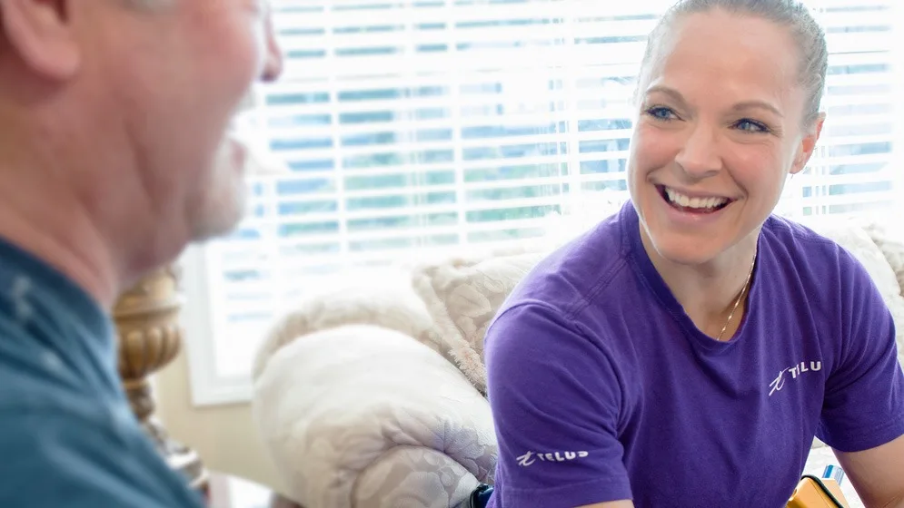 A TELUS technician talking to a customer