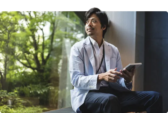 Person holding a tablet looking outside.