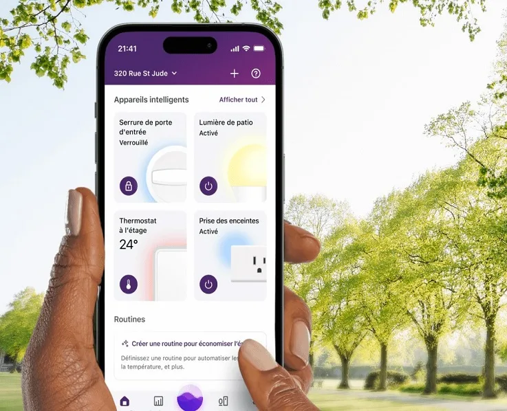 Une main tient un téléphone intelligent montrant l’interface de l’application de gestion de l’énergie