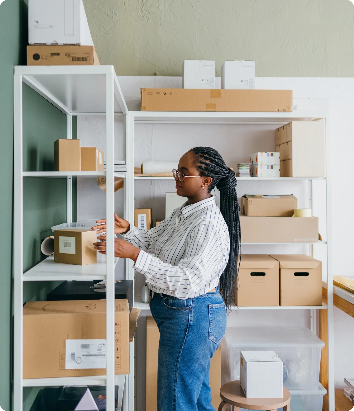 Small business owner organizes boxes on storage shelves in a stockroom.