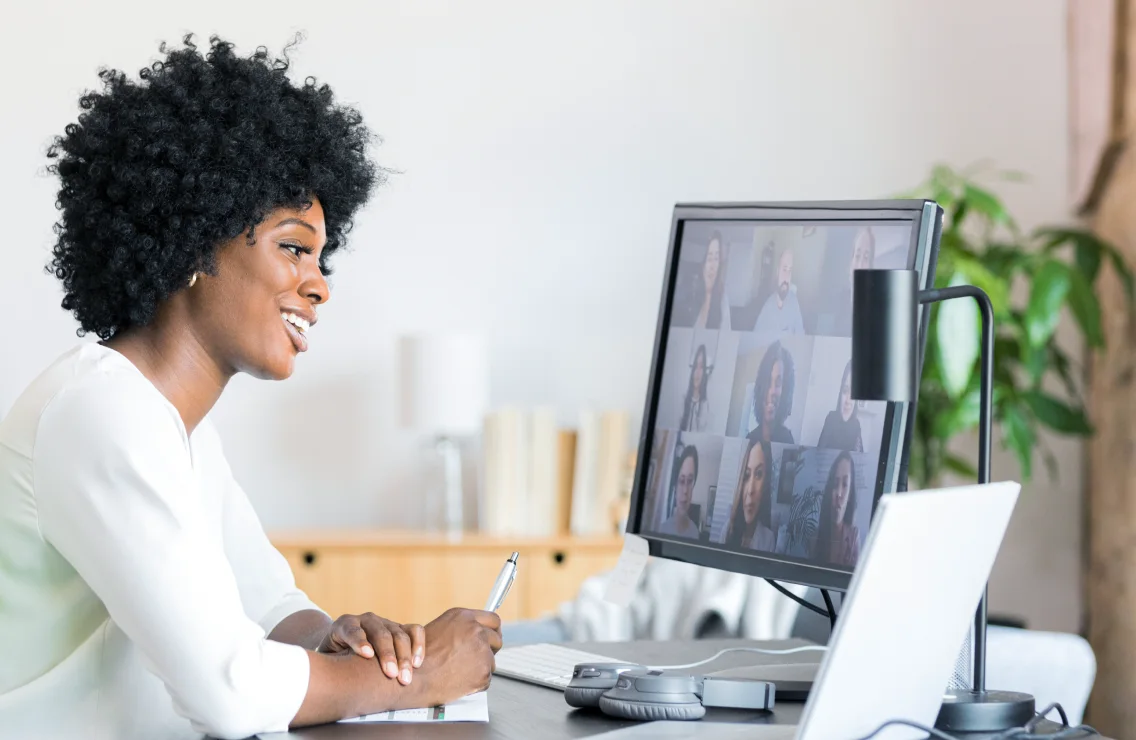 A person attending an online meeting virtually from home on their desktop computer.