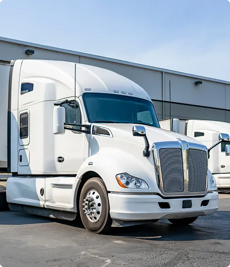 Raven-powered White semi-truck parked at commercial trucking facility.