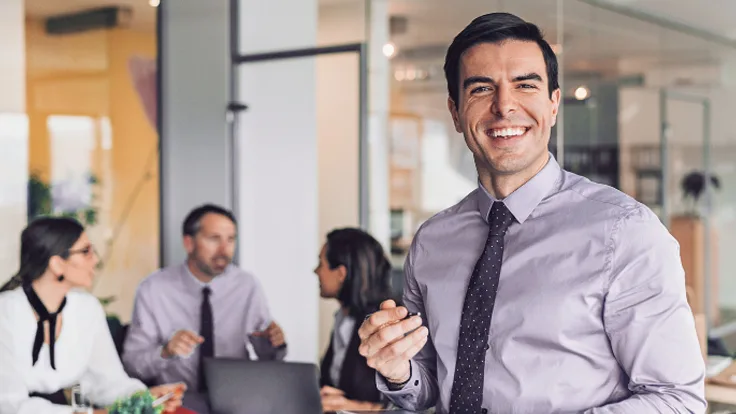 Smiling professional holding a tablet in a modern office