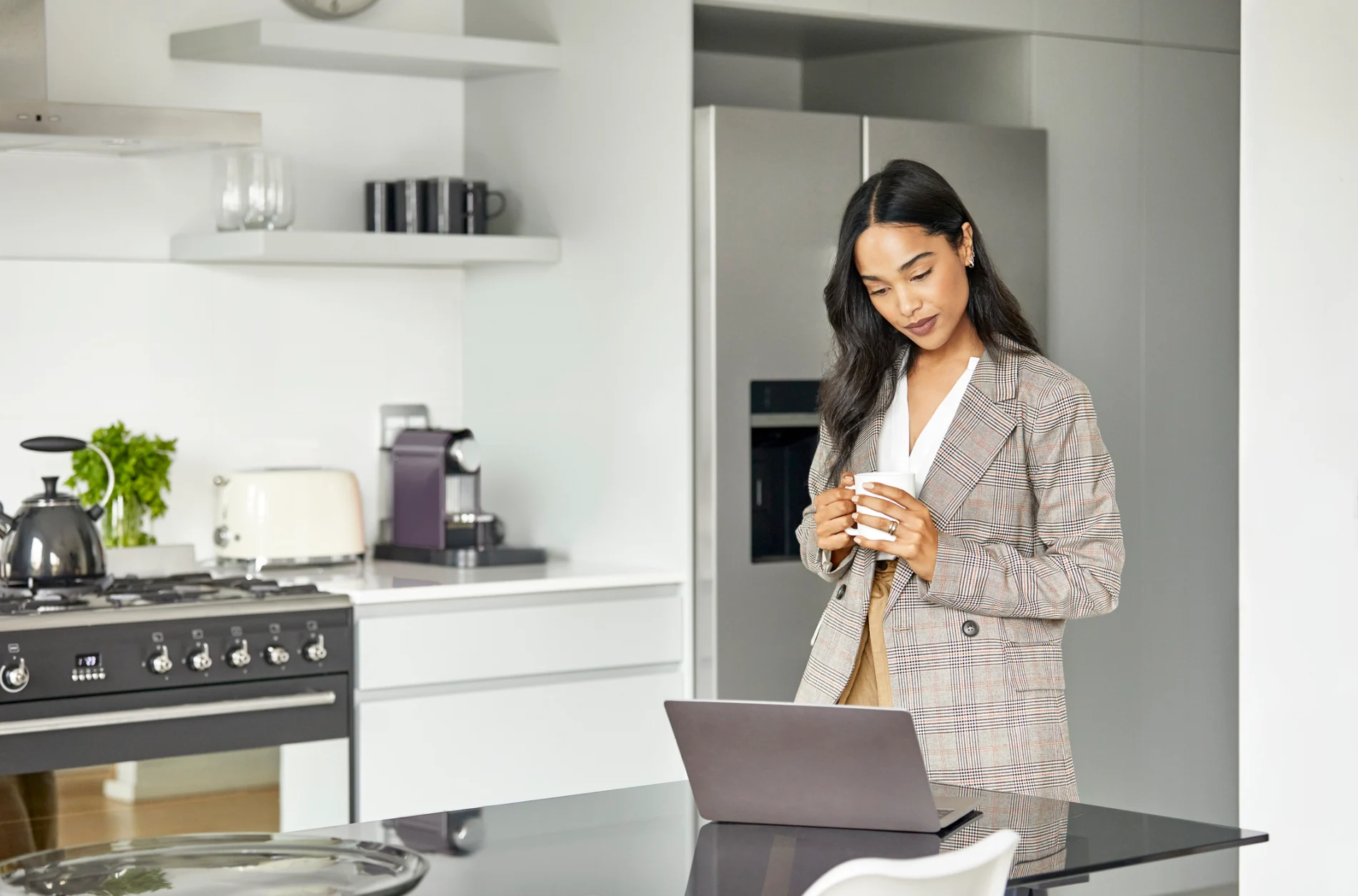 A woman looking at her laptop screen at home.