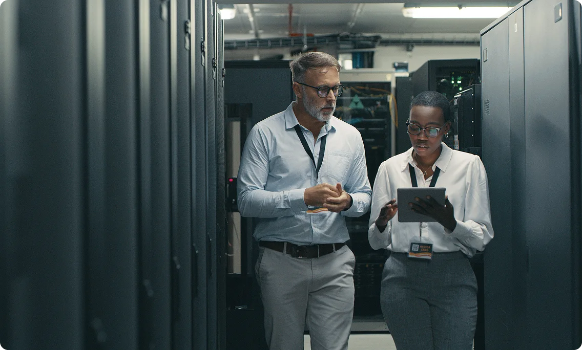 IT professionals discussing infrastructure management in a data center server room.