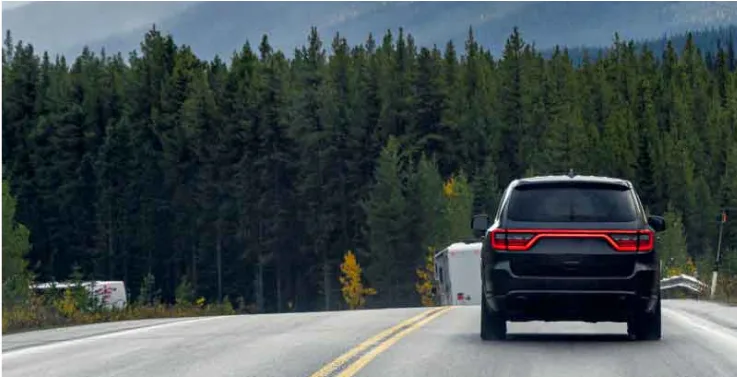 Car driving on scenic mountain highway through autumn forest