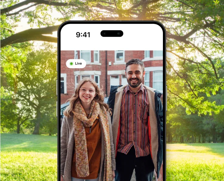 Téléphone intelligent affichant un appel vidéo avec un couple à l’extérieur