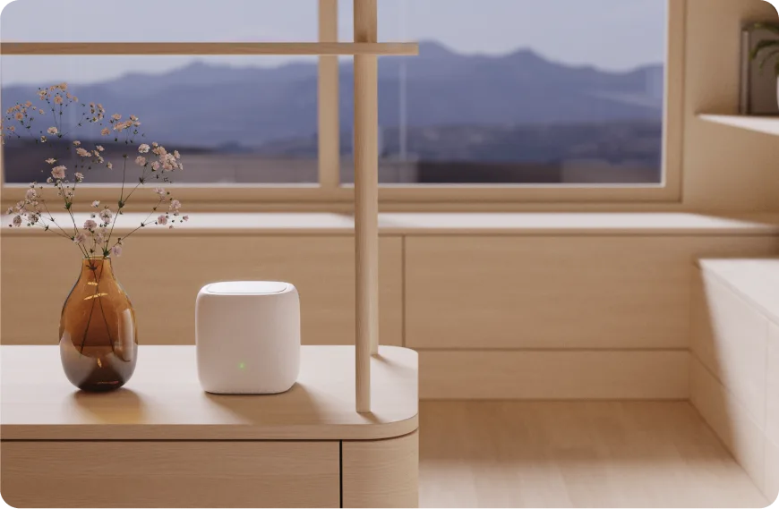 A TELUS modem on a table next to a vase.