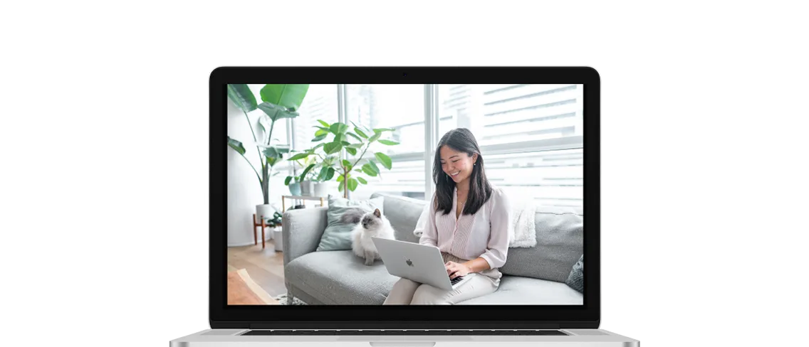 An open laptop showing a young woman sitting on her couch with her laptop and her cat