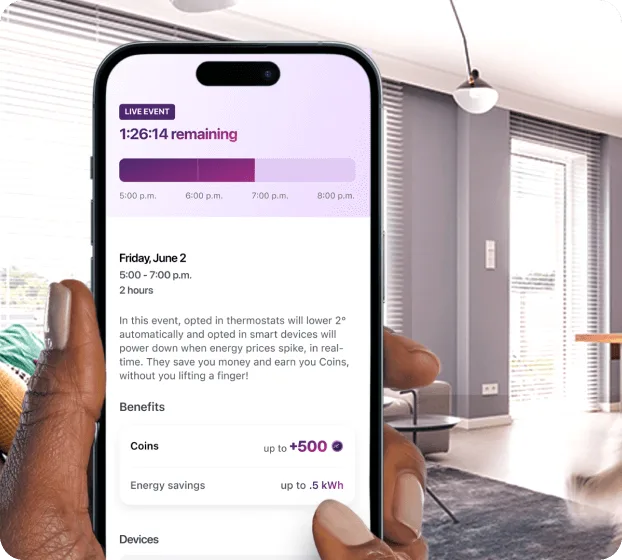 Hand holding smartphone showing energy rewards app with modern living room background