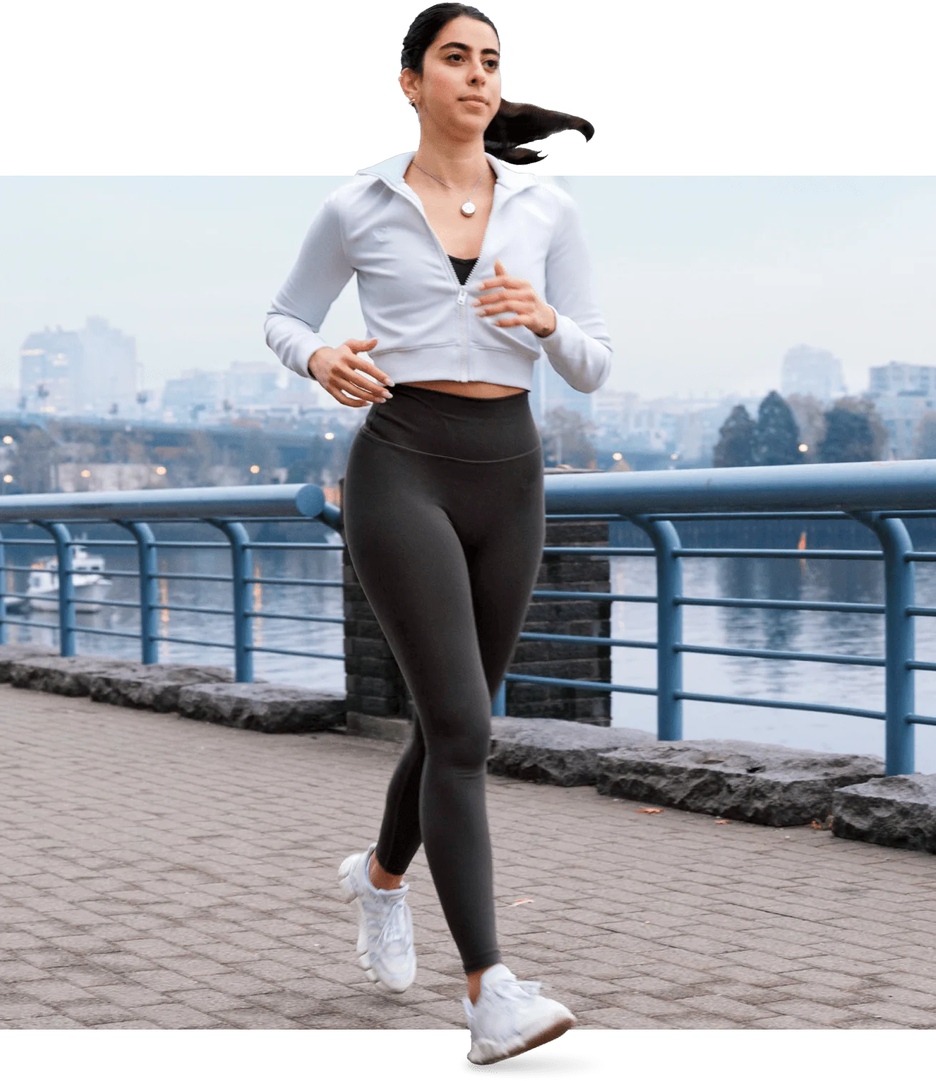 A woman wearing TELUS SmartWear device running along a seawall