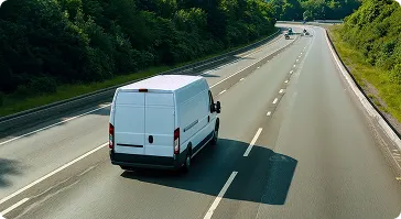 White delivery van driving on open highway.