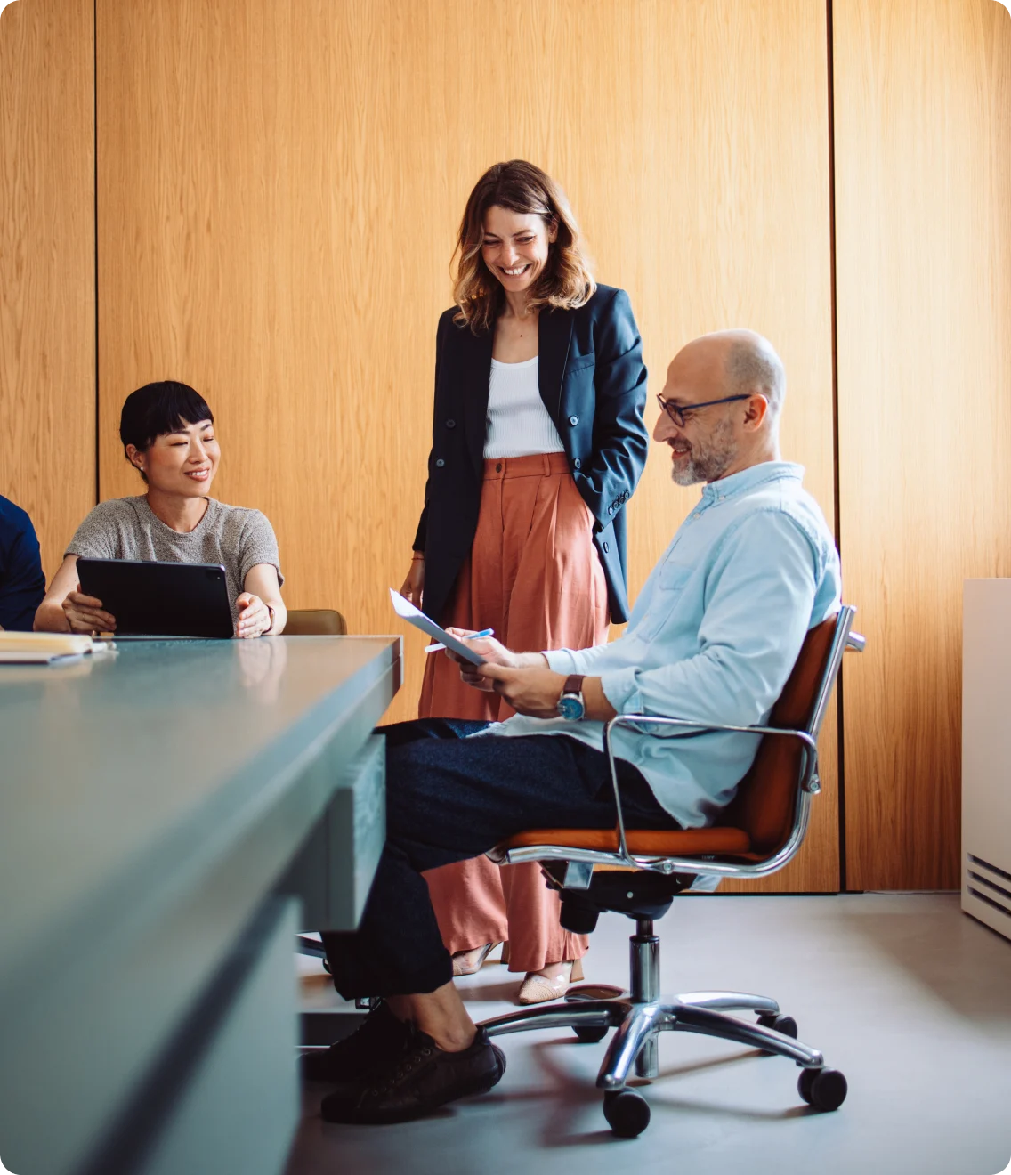 A team reviews documents together in a meeting room.