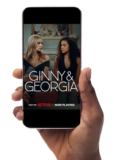 A hand holds a smartphone with the screen displaying Netflix’s 2025 film Ginny & Georgia.
