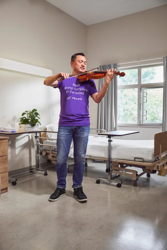 A TELUS team member playing the violin