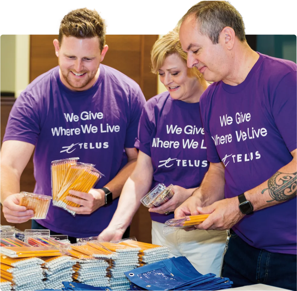 TELUS team members participating in the Kits for Kids program, filling backpacks with essential school supplies.