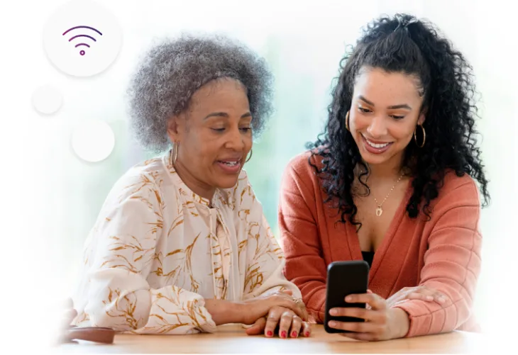An elderly woman and a lady conversing while using her mobile phone. TELUS Internet Icon can also be seen at the top.