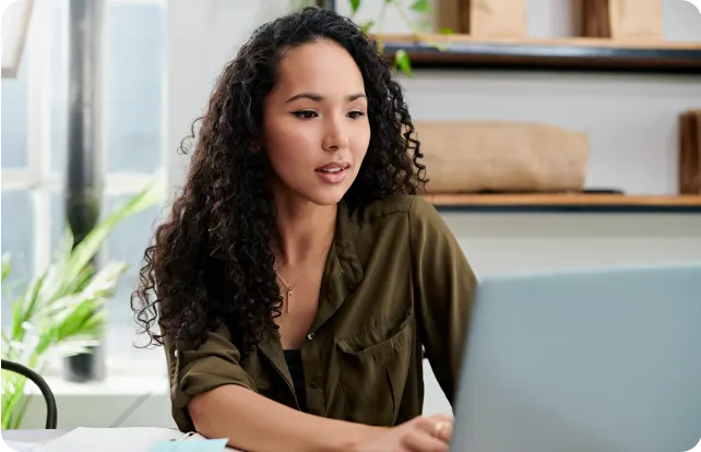 Woman smiling and using a laptop.