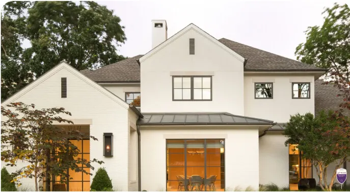 Maison blanche moderne avec garage et aménagement paysager dans la lumière du soir