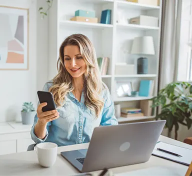 A woman using her laptop and phone.